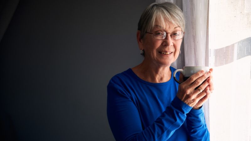 elderly-woman-drinking-hot-tea-to-keep-her-warm