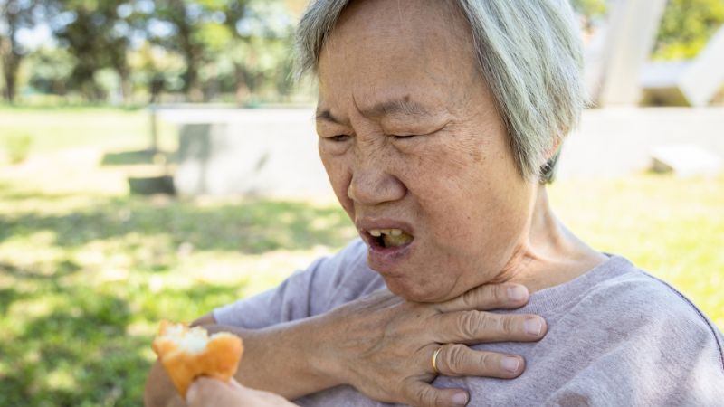senior woman choking on solid food