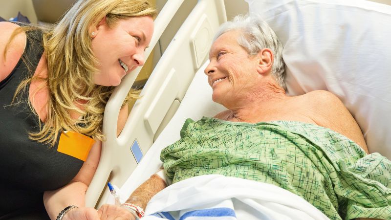 Daughter giving comfort to elderly mother who just had her hip replacement surgery