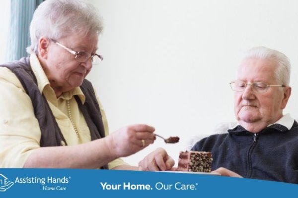 senior woman trying to feed her husband who has dementia