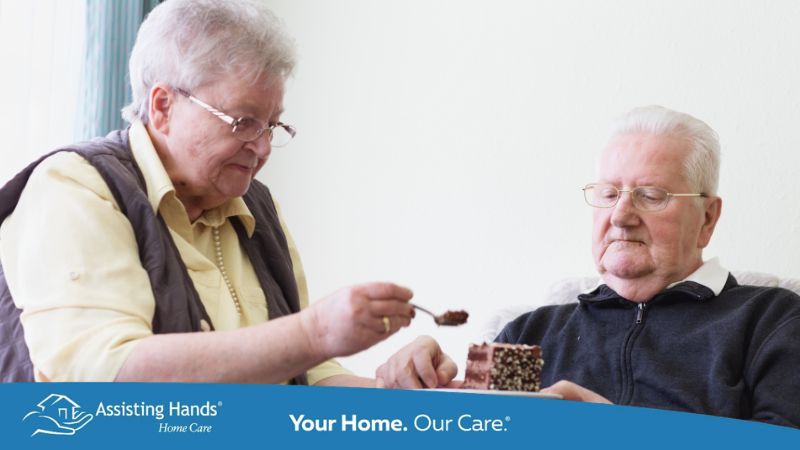 senior woman trying to feed her husband who has dementia