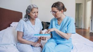 caregiver giving medicine to senior woman as a part of 24 hour home care little elm tx