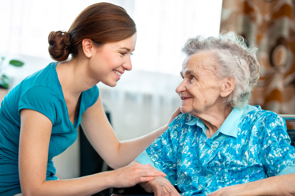 in-home-caregiver-helping-woman