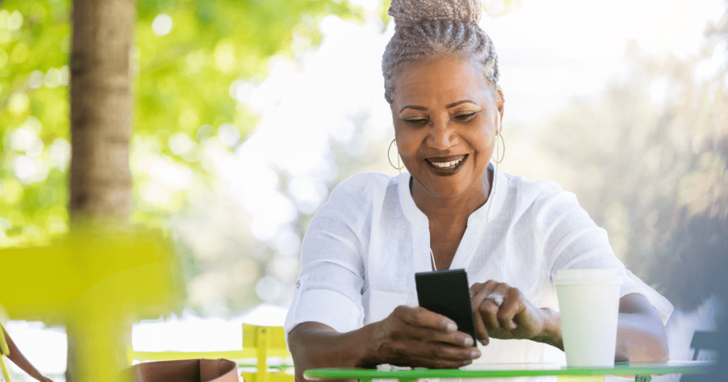 A senior woman uses caregiver apps on her smartphone to help her organize her schedule.