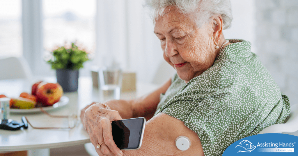 A senior woman uses her smartphone to check her glucose monitor, a tool that can be extremely helpful for diabetes care.