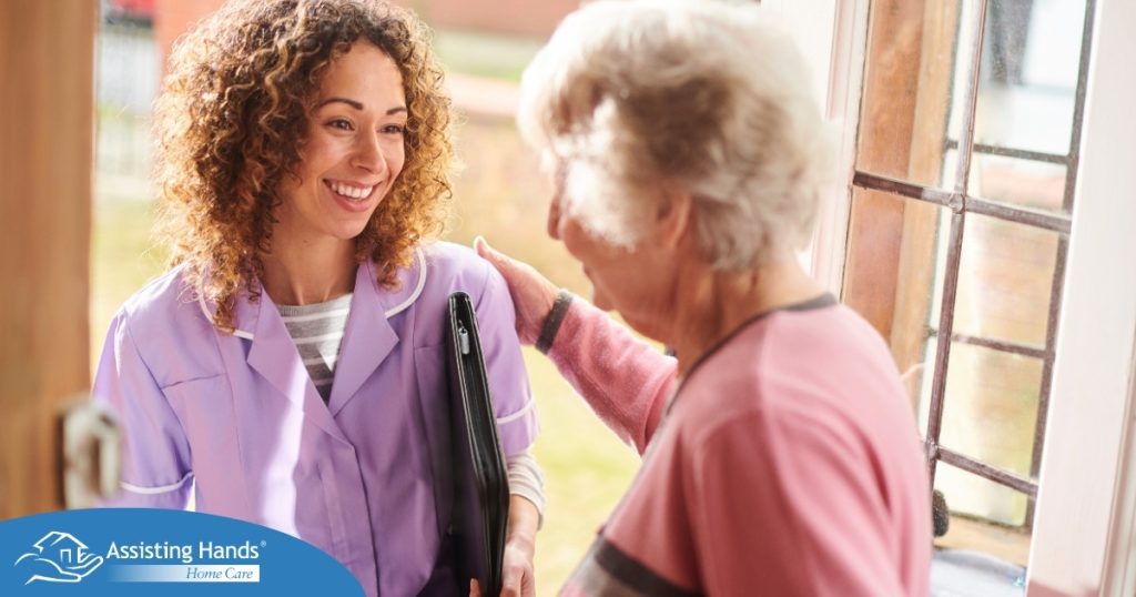 A happy caregiver enters the home of a client, representing in-home recovery care.