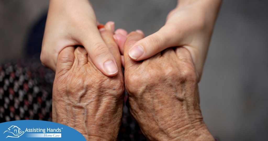 Younger hands hold older ones, representing the care and compassion of caregiving and how caregivers can help, even in ways like implementing stroke prevention strategies.