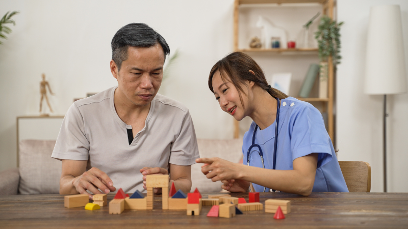 Asian Older Male Parkinson’S Patient Trying to Build Wood Brick