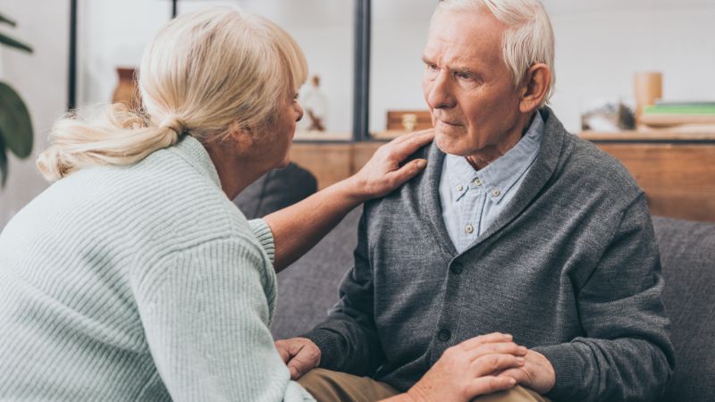 A family member comforting her husband who is receiving dementia care.