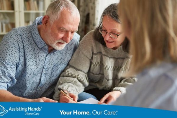 Elderly parent signing legal document with adult child