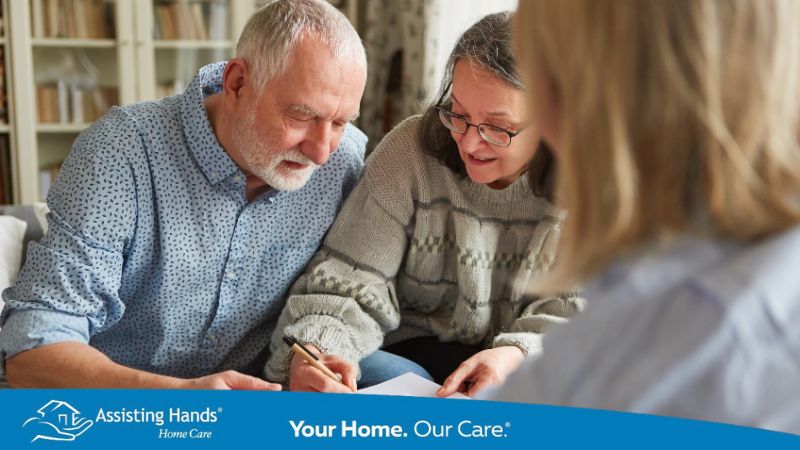 Elderly parent signing legal document with adult child