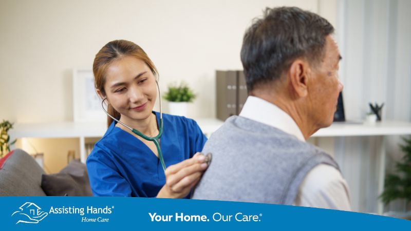Assisting Hands Home Caregiver checking senior man's lungs