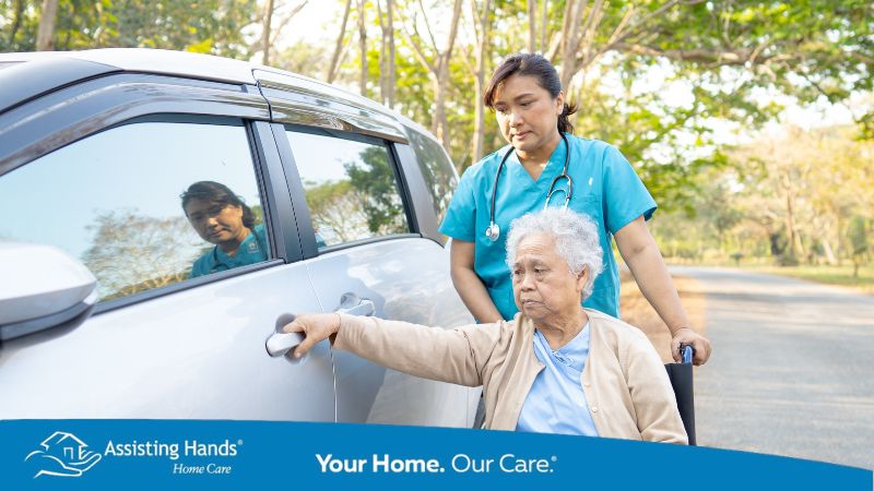 Caregiver assisting disabled senior to get seated in car and drive around
