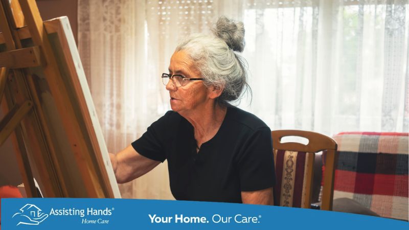 a senior woman who just suffered a stroke is doing artwork and sitting on the chair