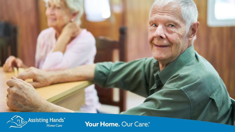 Senior with Dementia Sits at the Table and Plays Dominoes who is at stage 2 of dementia