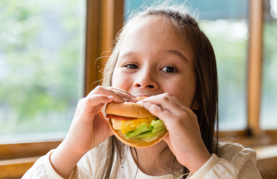 young girl eating sandwich